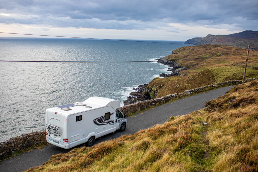 A campervan driving along irelands coastline